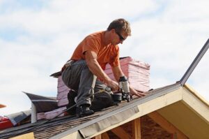Homeowner reviews roof damage with a roofing inspector beside a ladder and written inspection notes.